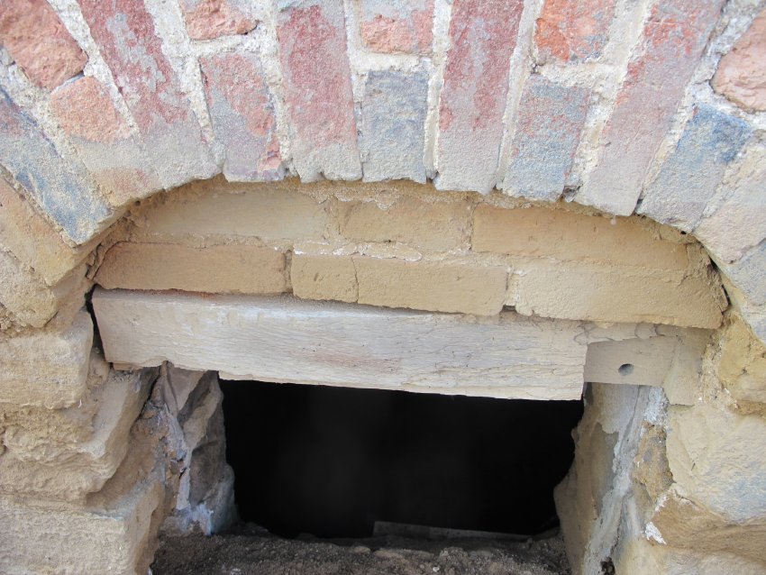 Image #8, arched cellar-vent opening lacking wooden bars